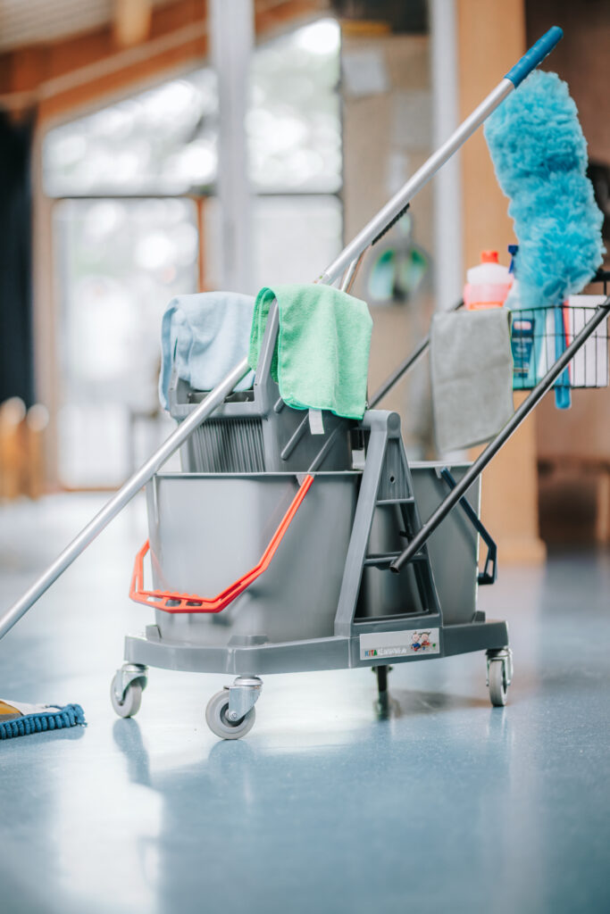 Reinigungswagen mit Mopp, Mikrofasertüchern und Reinigungsmitteln – bereit für die Unterhaltsreinigung in einer Kindertagesstätte